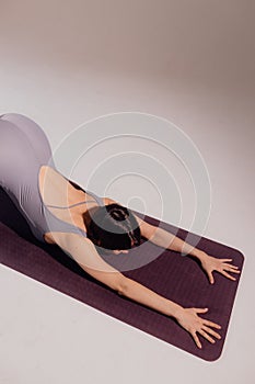 Sporty young woman doing yoga practice on white background. Concept of healthy life and balance between body and mental