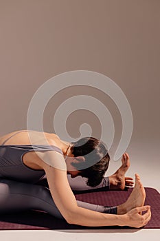 Sporty young woman doing yoga practice on white background. Concept of healthy life and balance between body and mental