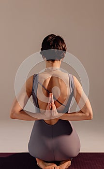 Sporty young woman doing yoga practice on white background. Concept of healthy life and balance between body and mental