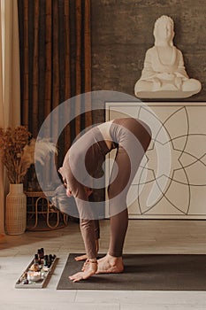 Sporty young woman doing yoga practice on yoga mat is in the yoga room. Vintage tonned. Concept of healthy life and natural