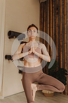 Sporty young woman doing yoga practice on yoga mat is in the yoga room. Vintage tonned. Concept of healthy life and natural