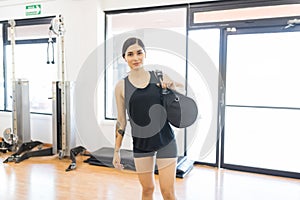 Sporty Young Woman With Duffle Bag Standing In Gym