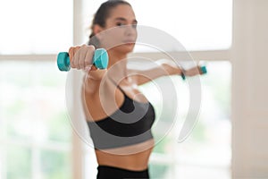 Sporty Young Woman Exercising With Two Dumbbells