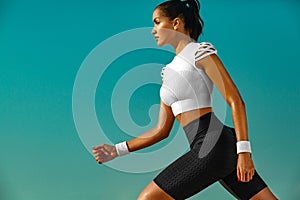 Sporty young woman and fit athlete runner running on the sky background. The concept of a healthy lifestyle and sport