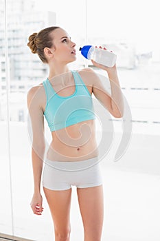 Sporty young woman holding water bottle