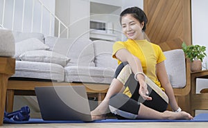 Sporty young woman practicing yoga at home, sitting on mat for relaxed yoga posture. Healthy lifestyle, wellbeing, meditation