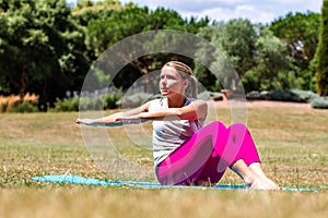 Sporty young woman toning up her arms in park