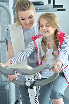 Sporty young woman training with teenage daughter