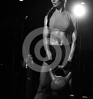 Sporty young woman working out with dumbbells weight in Gym. Diet and weight loss concept