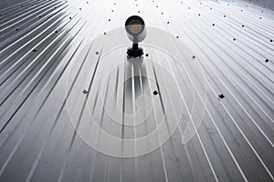 Spot light hanging on metal sheet wall on outdoor public area