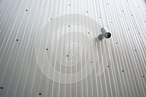 Spot light hanging on metal sheet wall on outdoor public area