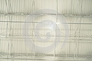 Spot light hanging at modern suspended ceiling metal roof structure, warehouse industry factory building lighting solution,