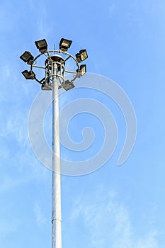 Spot-light tower at the road on blue sky