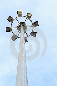 Spot-light tower at the road on blue sky