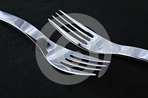 Spotless restaurant cutlery on black tablecloth