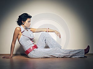 Spotlight, fashion and gen z girl on a studio floor with attitude, style and cool against a wall background. Edgy, cool