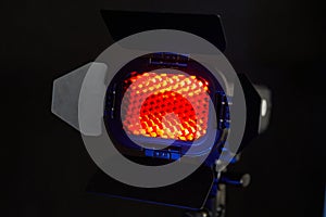 Spotlight with red light and honeycomb. Photo and video equipment for the Studio