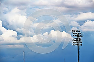 Spotlights, spotlights in the stadium, and blue skies and clouds.