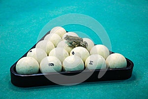 Spotted green frog on  pool table with old dirty billiard balls and shabby dusty green cloth. the concept of foul play, toad of