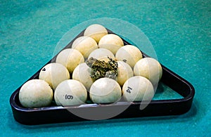 Spotted green frog on  pool table with old dirty billiard balls and shabby dusty green cloth. the concept of foul play, toad of