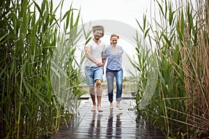 Spouses barefoot walking on a wet dock photo