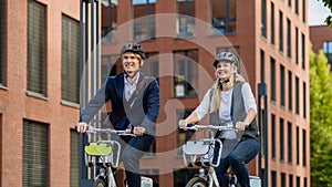 Spouses commuting through the city, talking and walking by bike on street. Middle-aged city commuters traveling from