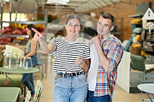 Spouses look for something in furniture store, searching for perfect item to complete patio