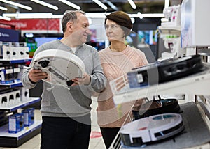 Spouses of mature age attentive choose a robot vacuum cleaner