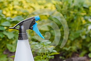 Spray bottle on a background of a potato field