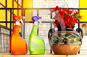 Spray bottle with beautiful red flowers on clay vase with cherry fruit painting above wood table