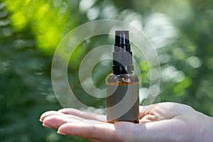 Spray Bottle on Open Hand in Natural Setting