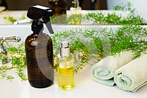 Spray bottles, towels and greens on bathroom countertop