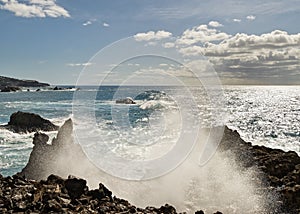 Spray drops of a wave at the stone beach