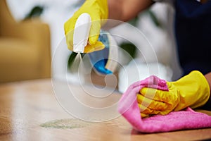 Spray, hands and person cleaning table, furniture and housekeeping services at home. Closeup of cleaner wipe surface