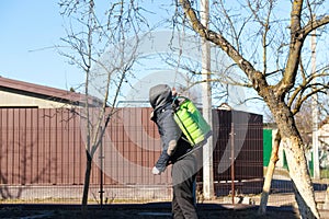 Spray pesticides, pesticide on tree. Defocus farmer man spraying tree with manual pesticide sprayer against insects in spring