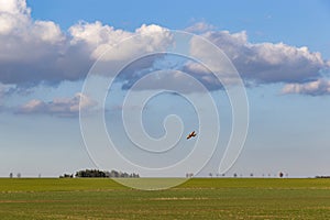 A spray plane applies chemicals to a field. Agricultural aviation