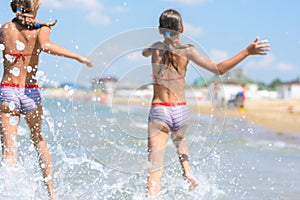 Spray soars after children run along the seashore