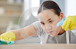 Spray, table and cleaning with a woman housekeeper using disinfectant to remove bacteria in a home. Safety, surface and