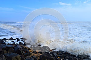 Spray of Water Drops with Hitting of Sea Wave to Rocks on Shore with Blue Sky - Ocean Natural Aqua Background