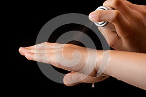 Spraying antiseptics on hands for disinfection on a black background