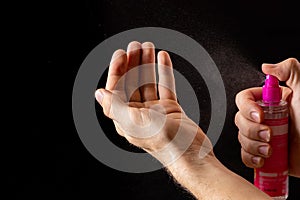 Spraying antiseptics on hands for disinfection on a black background