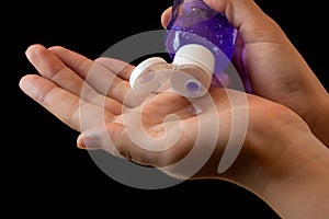 Spraying antiseptics on hands for disinfection on a black background