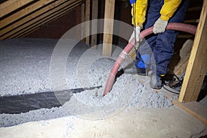 Spraying cellulose insulation in the attic of a house. Insulation of the attic or floor in the house photo