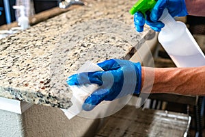 Sparying and Cleaning with Blue protective gloves and disinfecting surfaces for Covid-19 photo