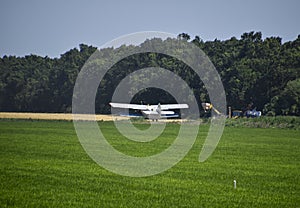 The spraying of fertilizers and pesticides on the field with the aircraft.