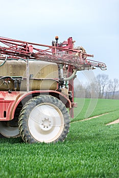 Spraying the herbicides on the green field photo