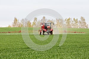 Spraying the herbicides on the large green field