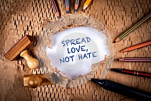 Spread love, not hate. Torn cardboard paper and office supplies