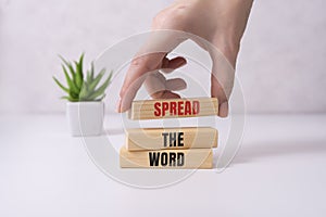 Spread thw word, a word written on a wooden block. Spread the word text on the table, concept