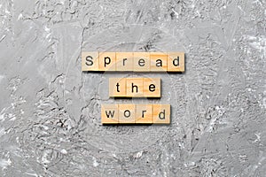 Spread the word word written on wood block. Spread the word text on table, concept